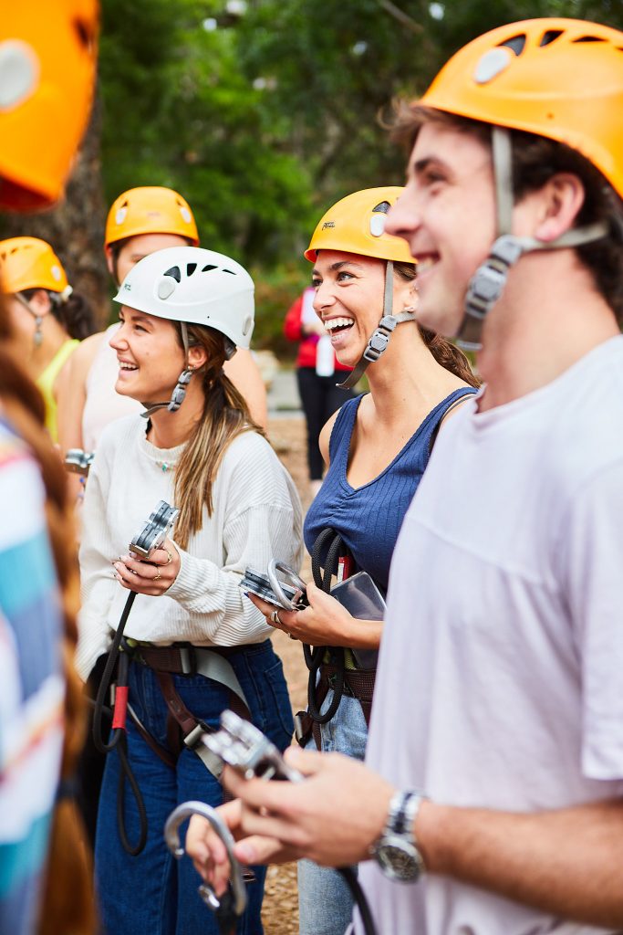 Close up of group of adults laughing and smiling listening to the safety brief from our instructors for the Grand Tree Surfing course at Enchanted Adventure