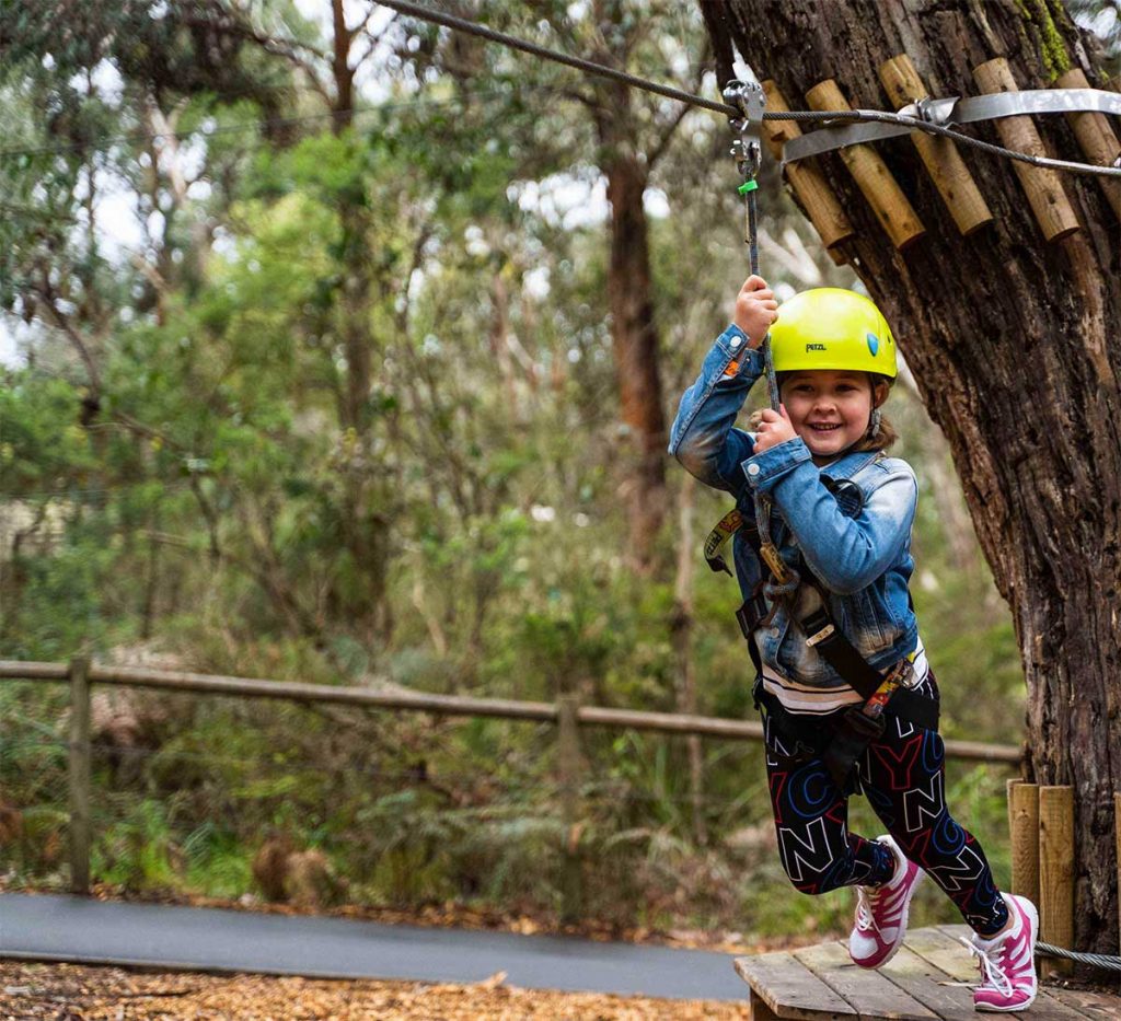 Young girl on zipline at the Nippers Tree Surfing Course at Enchanted Adventure